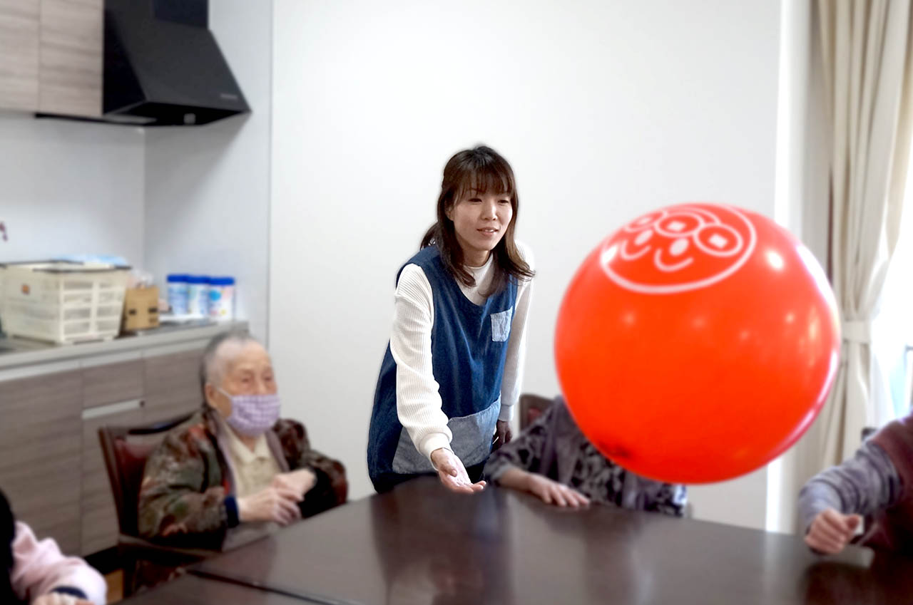 池田準子さんが利用者様と風船レクリエーションを行う様子
