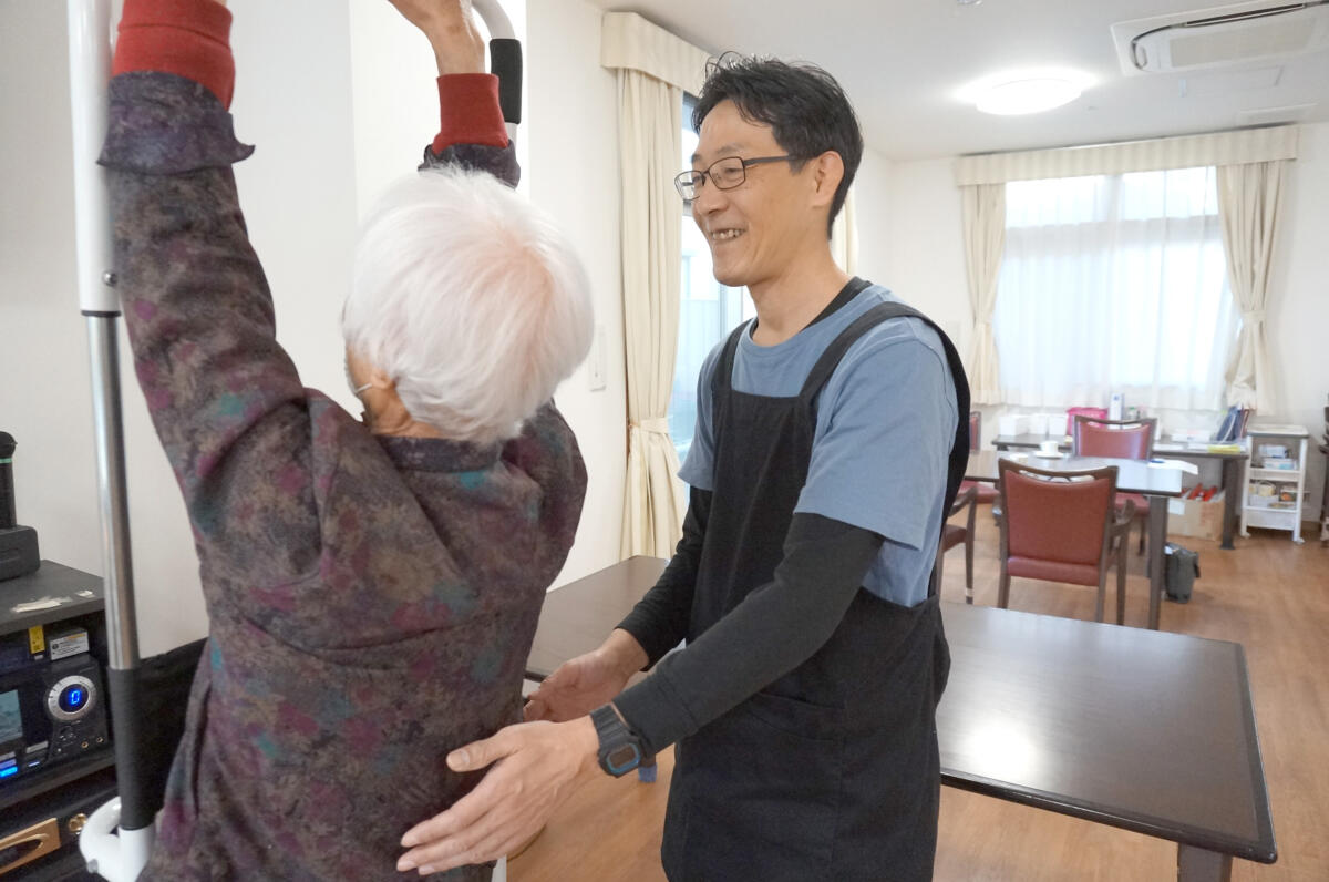 吉田武志さんが利用者様の立ち上がり・歩行をサポートする様子