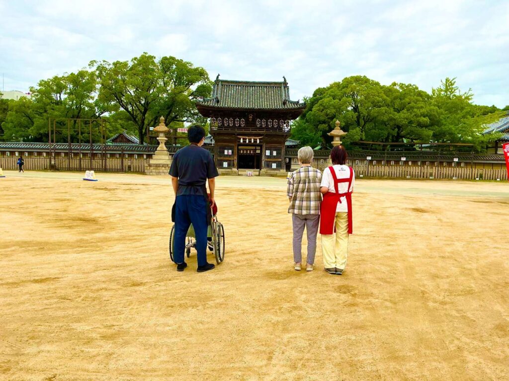 松原八幡神社の境内をスタッフと散歩する入居者様