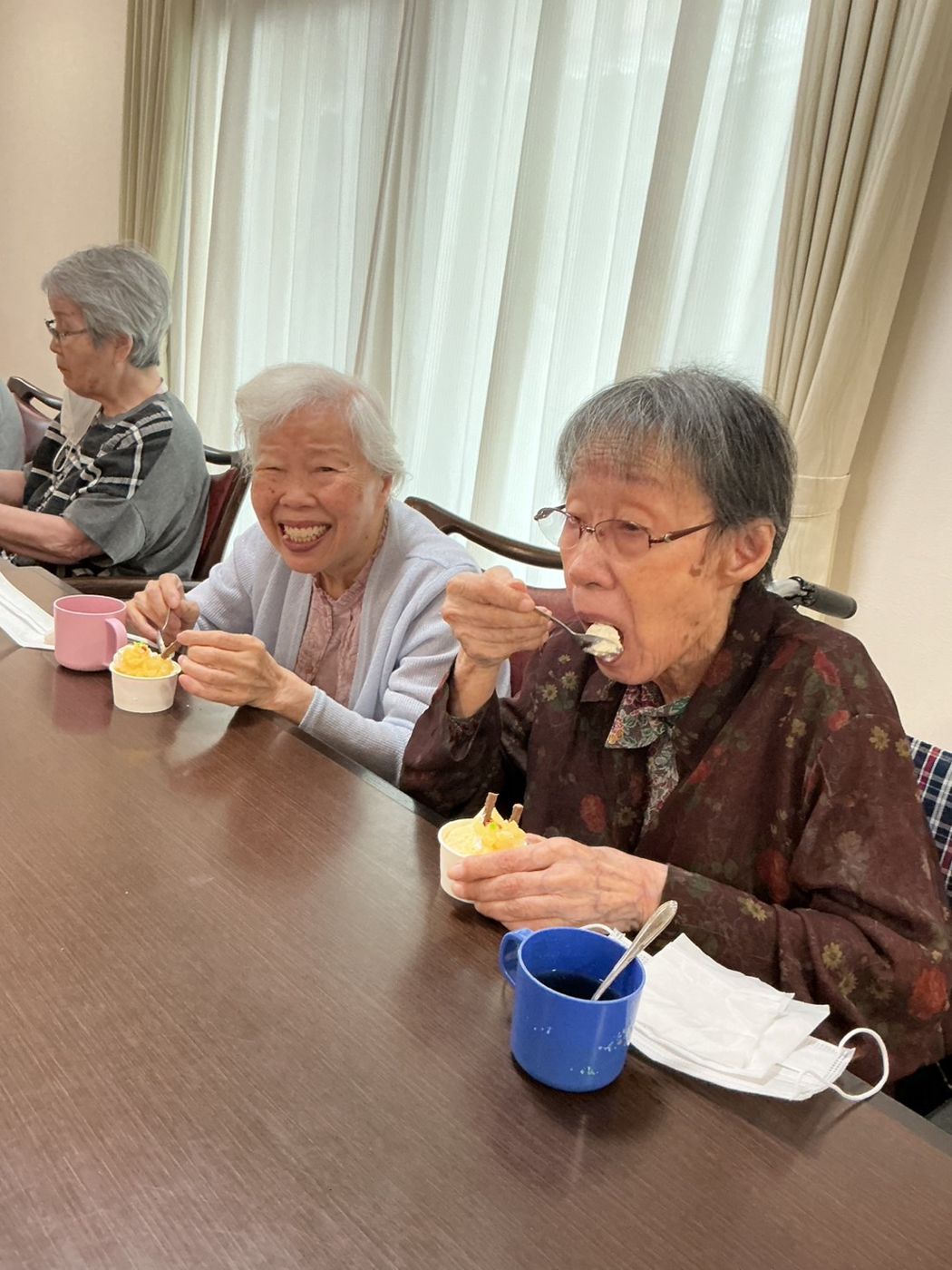 おやつを召し上がりながら笑顔を見せる入居者様